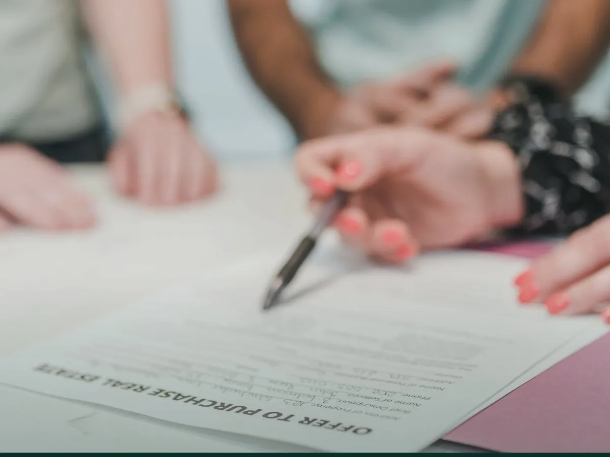 Buyers reviewing and signing a land purchase document