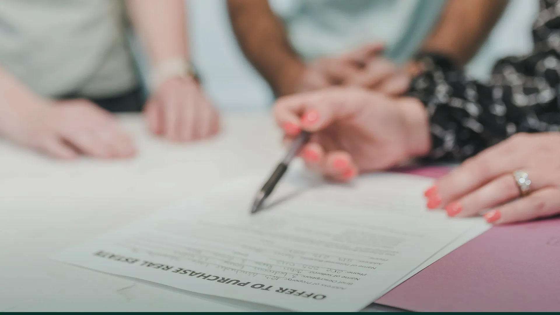 Buyers reviewing and signing a land purchase document